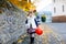 Little toddler girl dressed as a witch trick or treating on Halloween. Happy child outdoors, with orange funny hat and