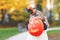 Little toddler girl dressed as a witch trick or treating on Halloween. Happy child outdoors, with orange funny hat and