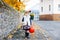 Little toddler girl dressed as a witch trick or treating on Halloween. Happy child outdoors, with orange funny hat and