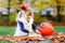 Little toddler girl dressed as a witch trick or treating on Halloween. Happy child outdoors, with orange funny hat and