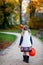 Little toddler girl dressed as a witch trick or treating on Halloween. Happy child outdoors, with orange funny hat and