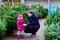 Little toddler girl and father holding Christmas tree on a market. Happy family, cute baby child daughter and middle