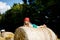 Little toddler girl having fun with running and jumping on hay stack or bale. Funny happy healthy child playing with