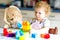 Little toddler girl with plush bunny playing with educational plastic colorful blocs toys. child having fun. Creative