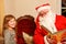 Little toddler girl talking to Santa Claus called Nikolaus or Weihnachtsmann in German. Happy smiling kid waiting for