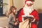 Little toddler girl talking to Santa Claus called Nikolaus or Weihnachtsmann in German. Happy smiling kid waiting for