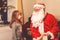 Little toddler girl talking to Santa Claus called Nikolaus or Weihnachtsmann in German. Happy smiling kid waiting for