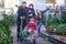 Little toddler girl, two kids boys and father holding Christmas tree on market. Happy family, cute children and middle