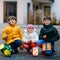 Little toddler girl and two kids boys holding selfmade lanterns with candle for St. Martin procession. Three Healthy