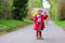 Little toddler girl walking with umbrella