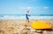 Little toddler pull surfboard to the sea waves