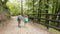 Little tourists boy and girl holding hands go to family camping along a gravel forest road in the Alps mountains. Children with
