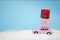 Little toy car rides in the snow and taking boxes with gifts, Christmas transport concept