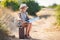 Little traveler studies the map while sitting on the old suitcase