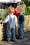 Little twin boys with blond hair watering the garden