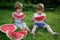 Little Twin Brothers Eating Watermelon on Green Grass in Summer Park