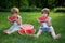 Little Twin Brothers Eating Watermelon on Green Grass in Summer Park