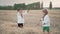 Little ukrainian children playing with hay, throw it up. Happy childhood. Smiling boys having fun at wheat field after