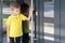 A little upset boy holding on to the door handle can't open the door. The child returns home