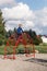 A little very brave boy climbs a metal, big red arched ladder on the playground. The concept of parental care and safety in