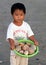 Little vietnamese boy selling shells on the beach