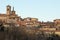 Little village with church and bell tower on top of the hill