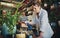 A little water does them a world of good. an attractive young florist watering plants inside a plant nursery with her