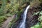 Little waterfall and geological mountain folds in the mountains