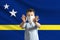 Little white boy in a protective mask on the background of the flag of Curacao. Makes a stop sign with his hands, stay at home