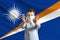 Little white boy in a protective mask on the background of the flag of Marshall Islands. Makes a stop sign with his hands, stay at