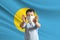 Little white boy in a protective mask on the background of the flag of Palau. Makes a stop sign with his hands, stay at home Palau