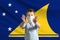Little white boy in a protective mask on the background of the flag of Tokelau. Makes a stop sign with his hands, stay at home