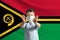 Little white boy in a protective mask on the background of the flag of Vanuatu. Makes a stop sign with his hands, stay at home