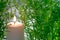 Little white candle lies with green leaves with soft light effect. Religion concept and relax or meditation caption