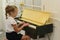 A little white girl plays the piano in the room. which is a classic education for kids, learning art.