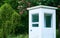 Little white guard booth in green spring park with pink sweet chestnuts. The room for work.