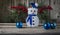 Little white toy snow man with blue scarf and hat on wood background.