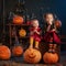 Little witches with Halloween pumpkins indoor