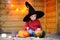 Little wizard playing with halloween pumpkins