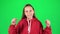 Little woman feeling happy and satisfied showing yeah in studio on green background. Slow motion