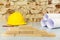 Little wooden blocks, safety helmet and drawings project on brick wall background