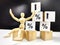 A little wooden man, cubes in a pyramid and growth arrows and percent signs. The concept of applying efforts that lead