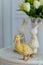 Little yellow duckling sitting on a table with flowers