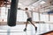 Little young fighter using punching bag during taining