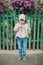 Little young girl sniffs a flower. on a background of green fe