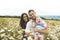 Littlegirl and his father and mother enjoying outdoors in field of daisy flowers