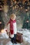 Littlw toddler child with suitcase and little gingerman toy in hand, walking in a snowy forest, christmas picture