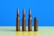 Live and blank gun cartridges on blue yellow background close up. War and peace concept, hope concept. Ukraine flag colors