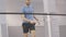 Live camera follows movement of young positive Caucasian sportsman playing badminton in gym. Portrait of bearded