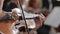 Live concert, woman plays on wooden violin classical music on a blurred background